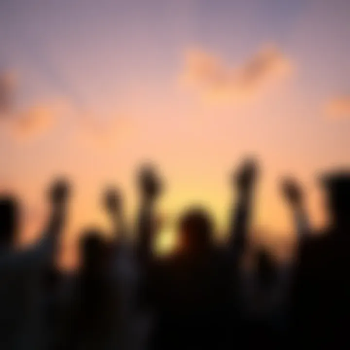 A group of people standing together, raising their hands in a gesture of hope and unity during a sunset.