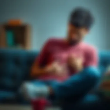A person sitting on a couch, looking worried with a hand on their stomach, showing signs of discomfort and anxiety.