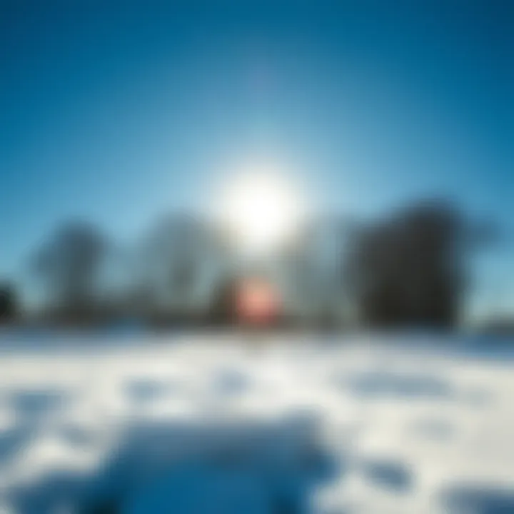 A bright sun shining in a clear blue sky, melting leftover snow on the ground, signaling the end of a cold spell.
